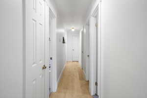 Corridor with light wood-style floors and baseboards