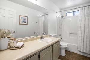 Bathroom featuring vanity and shower / bathtub combination with curtain