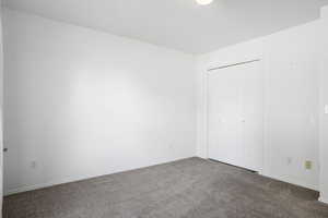 Unfurnished bedroom featuring carpet and a closet