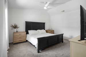 Bedroom featuring light colored carpet, lofted ceiling, and a ceiling fan
