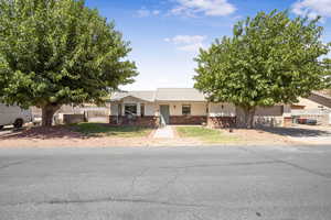 View of front of home featuring brick siding, an attached garage, and a metal roof