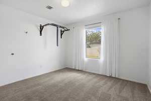 Carpeted spare room with baseboards