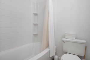 Full bath featuring toilet and shower / tub combo