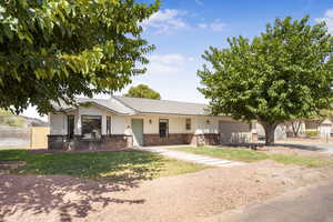 Ranch-style house with brick siding, driveway, a garage, and a metal roof