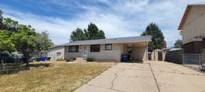 Ranch-style house featuring a shed, concrete driveway, a carport, and brick siding
