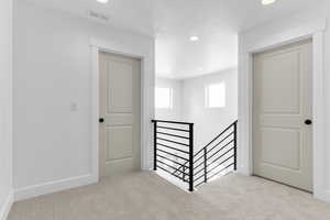 Corridor featuring an upstairs landing, carpet flooring, and recessed lighting