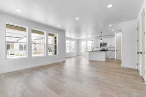 Unfurnished living room with recessed lighting, light wood-style flooring, and a textured ceiling