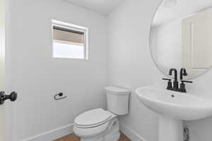 Half bathroom with toilet and baseboards