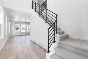 Stairway with hardwood / wood-style flooring and recessed lighting