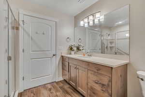 Bathroom featuring vanity, a shower stall, and wood finished floors
