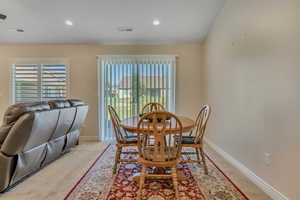 Dining area with light carpet and recessed lighting