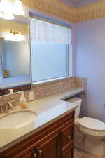 Bathroom featuring vanity, decorative backsplash.