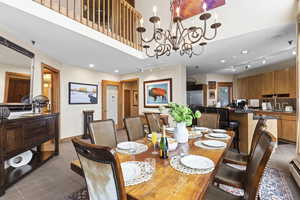 Dining area featuring rail lighting, dark tile patterned floors, and a chandelier