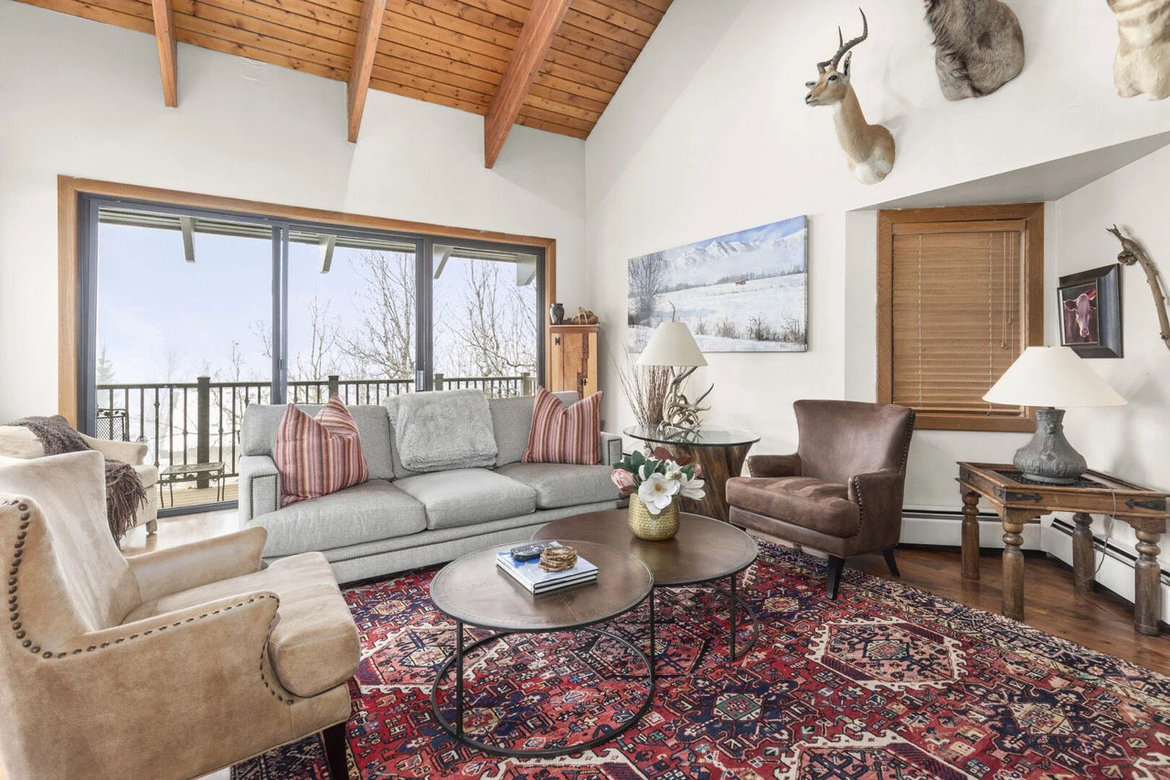 Living area featuring a wood ceiling with exposed beams, wood finished floors, and high vaulted ceiling