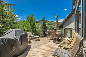 Wooden deck featuring grilling area and outdoor dining space
