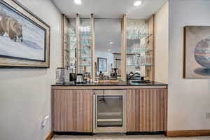 Indoor wet bar featuring wine cooler and recessed lighting