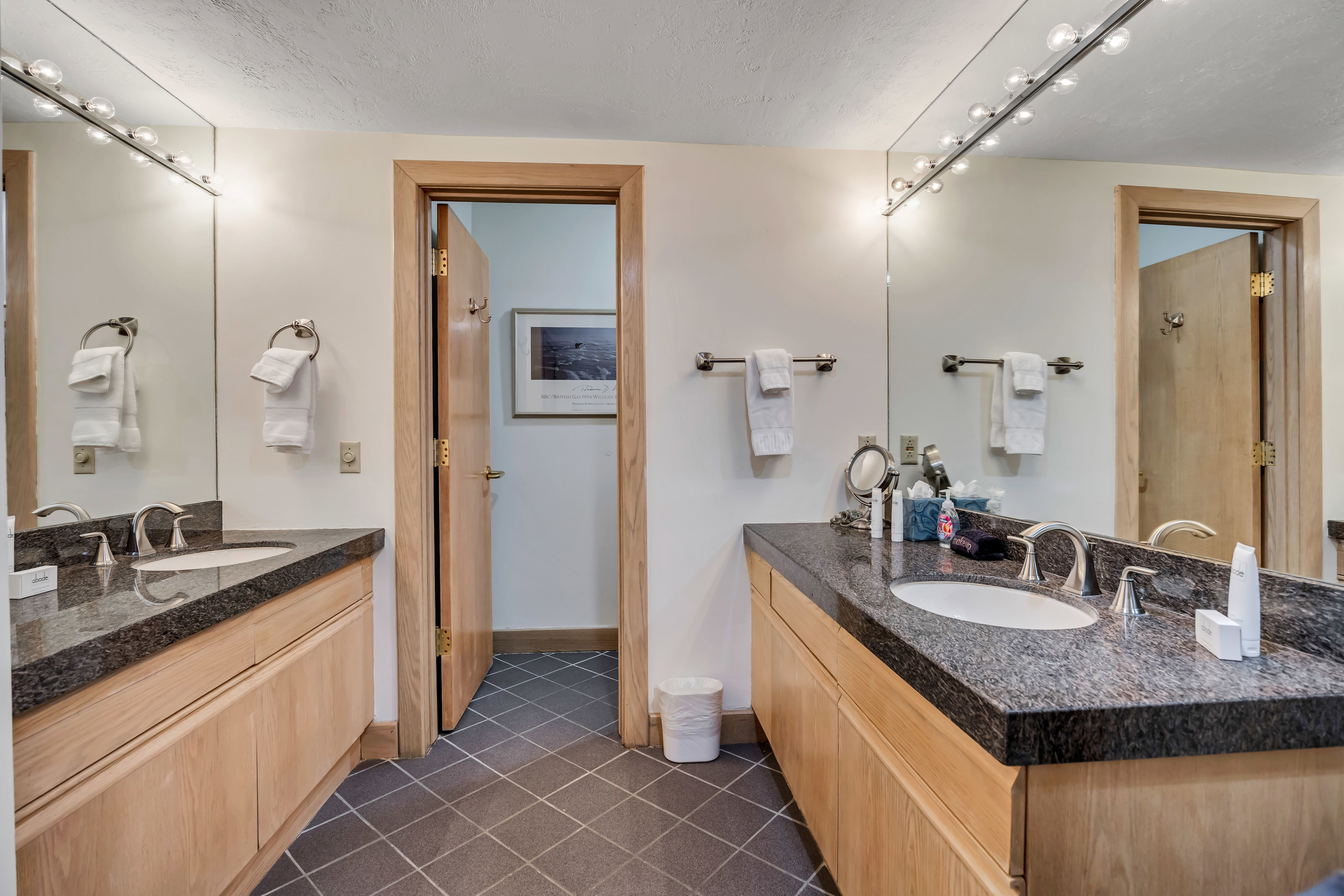 Full bathroom featuring two vanities and tile patterned flooring