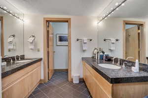 Full bathroom featuring two vanities and tile patterned flooring