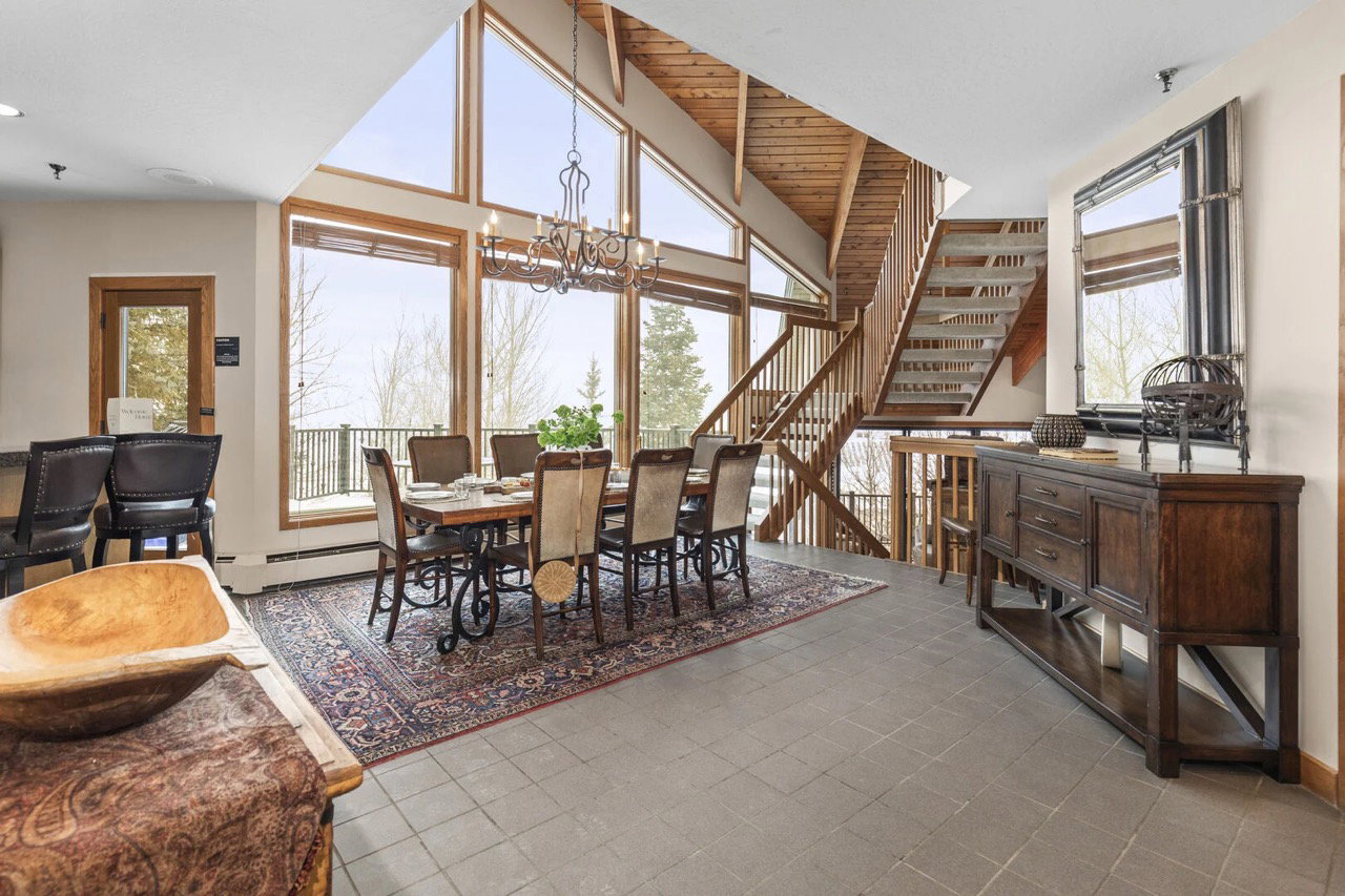 Dining room featuring a chandelier, stairway, and tile patterned floors