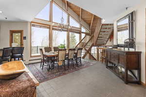 Dining room featuring a chandelier, stairway, and tile patterned floors