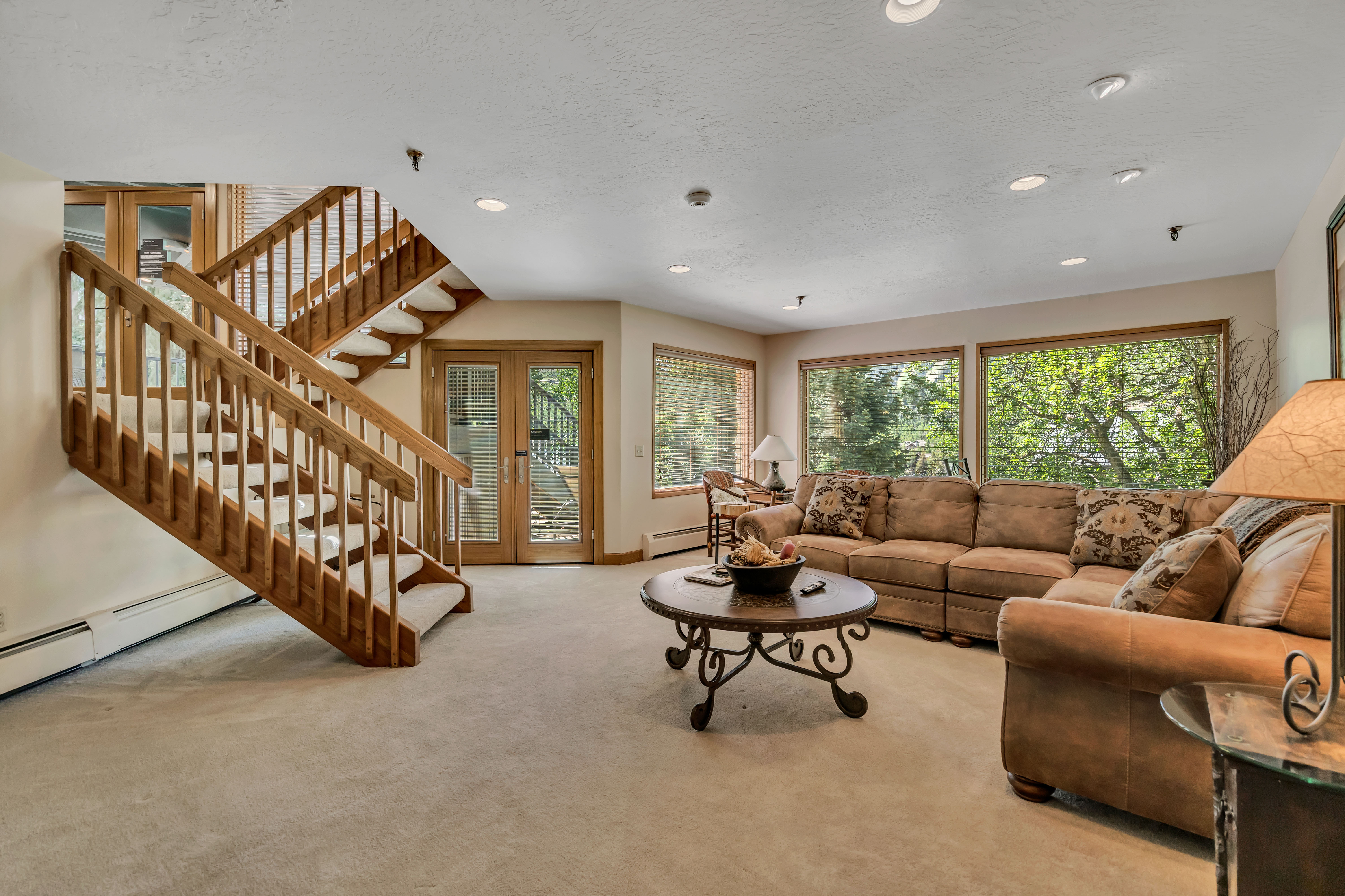 Carpeted living area featuring baseboard heating, stairway, recessed lighting, a textured ceiling, and french doors