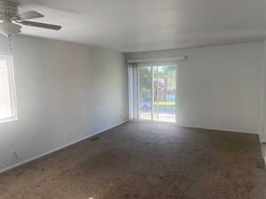 Unfurnished room featuring carpet floors and a ceiling fan