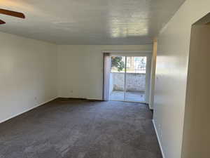 Spare room with dark colored carpet and a textured ceiling