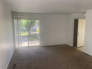 Carpeted empty room featuring baseboards