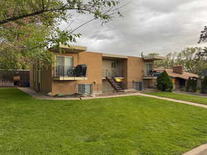 Rear view of property with brick siding and stairway