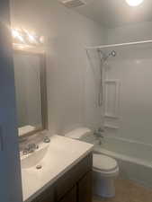 Bathroom featuring vanity, bathtub / shower combination, and light tile patterned flooring