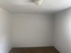 Unfurnished room with baseboards and dark colored carpet