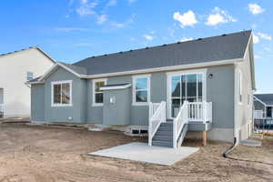 Rear view of property with a patio, stucco siding, and a shingled roof