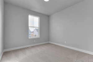 Empty room featuring light carpet and baseboards