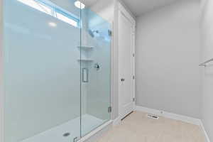 Full bath with a stall shower and light tile patterned flooring