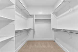 Walk in closet with light colored carpet