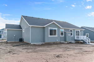 Rear view of property featuring a shingled roof and stucco siding
