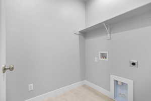 Laundry area featuring hookup for an electric dryer, washer hookup, and light tile patterned floors