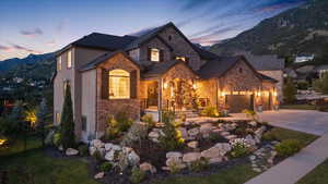 View of front of home with stone/brick siding, concrete driveway, and a mountain view