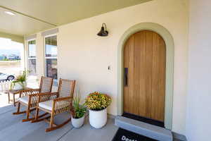Doorway to property featuring a porch and stucco siding