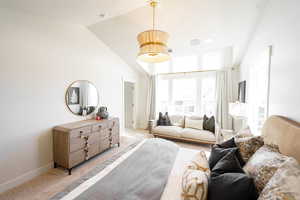 Bedroom with light colored carpet and vaulted ceiling