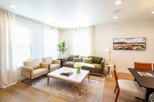 Living area featuring light wood-style floors and recessed lighting