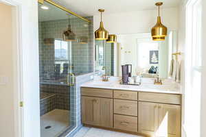 Full bath featuring double vanity, a shower stall, and tile patterned floors