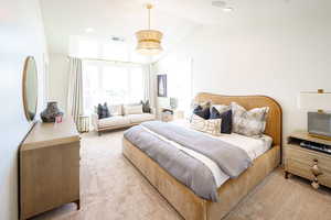 Bedroom with light colored carpet, lofted ceiling, and recessed lighting