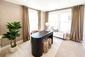 Office area featuring wallpapered walls and light carpet