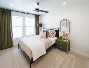 Bedroom with light colored carpet, ceiling fan, and recessed lighting