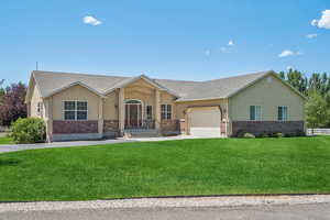 Ranch-style house with stucco siding, an attached garage, concrete driveway, and brick siding