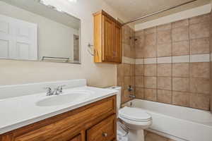 Full bath featuring vanity, tub / shower combination, a textured ceiling, and tile patterned flooring