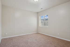 Empty room with carpet and baseboards