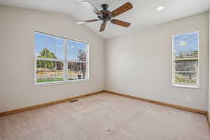 Unfurnished room with plenty of natural light, light colored carpet, ceiling fan, vaulted ceiling, and recessed lighting
