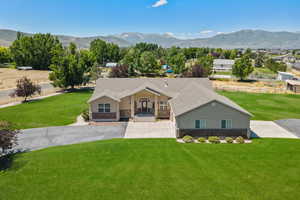 Ranch-style home with stone siding, a mountain view, and a front yard